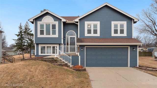 bi-level home featuring a garage and a front lawn