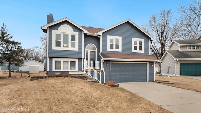 raised ranch featuring a garage and a front lawn