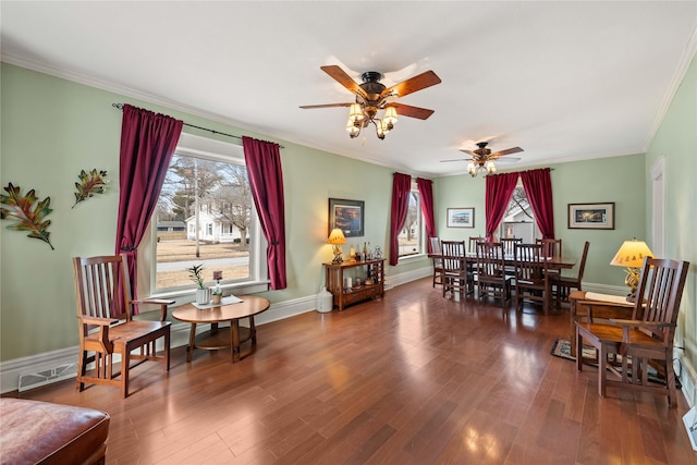 dining area featuring dark wood-type flooring, ornamental molding, and ceiling fan