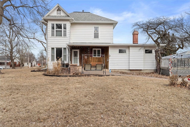 rear view of house with a yard and covered porch