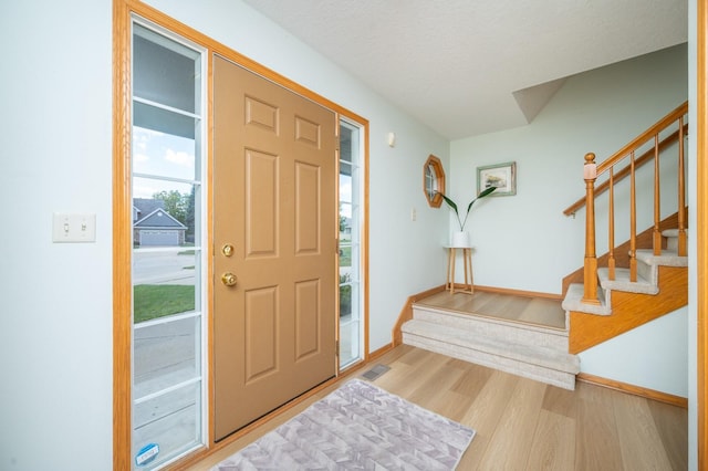 entryway with hardwood / wood-style flooring and a textured ceiling