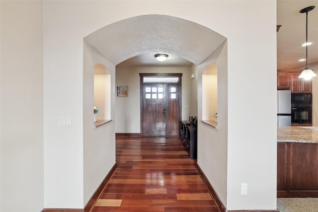 foyer with dark hardwood / wood-style flooring and a textured ceiling