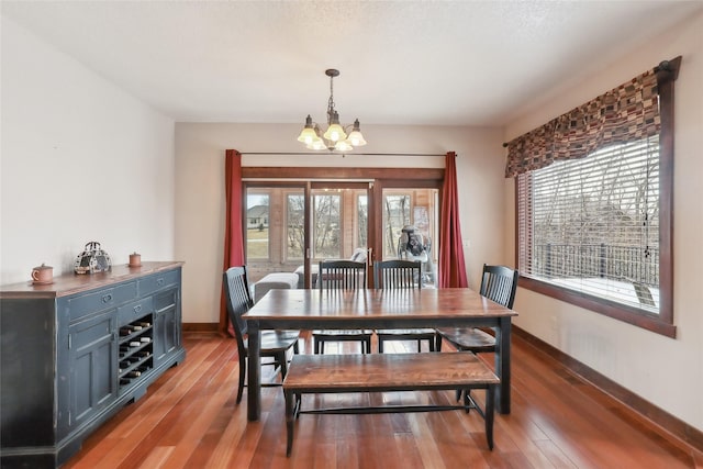 dining room with an inviting chandelier, dark wood-type flooring, and a wealth of natural light