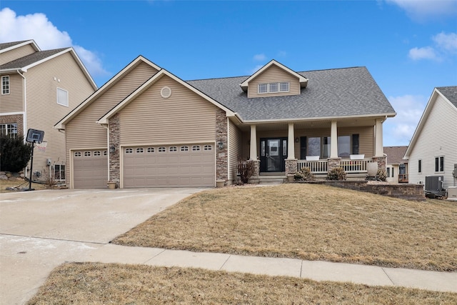 view of front of property with a porch, a garage, a front yard, and central air condition unit