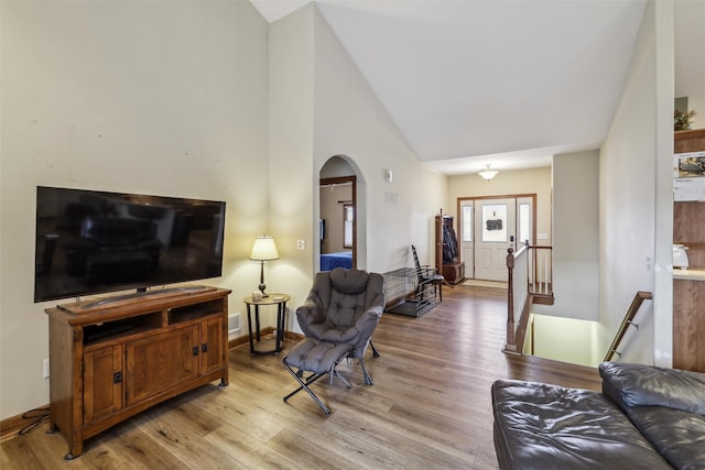 living room featuring high vaulted ceiling and light hardwood / wood-style floors