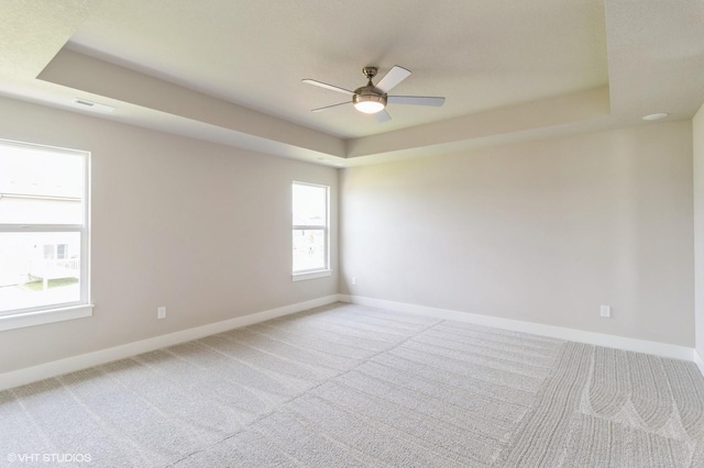 15019 Springbrook Trl, Urbandale, IA 50323 - empty room with a raised ceiling, light colored carpet, and ceiling fan