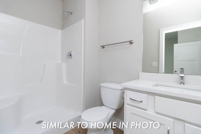 bathroom featuring a shower, toilet, and vanity