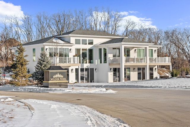 view of front of home featuring stucco siding and a balcony