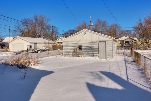 snowy yard with an outbuilding and a garage