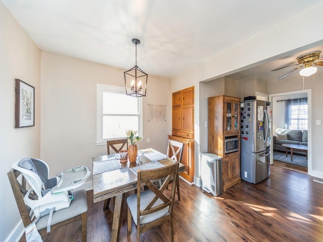 dining area with dark wood-type flooring and ceiling fan with notable chandelier