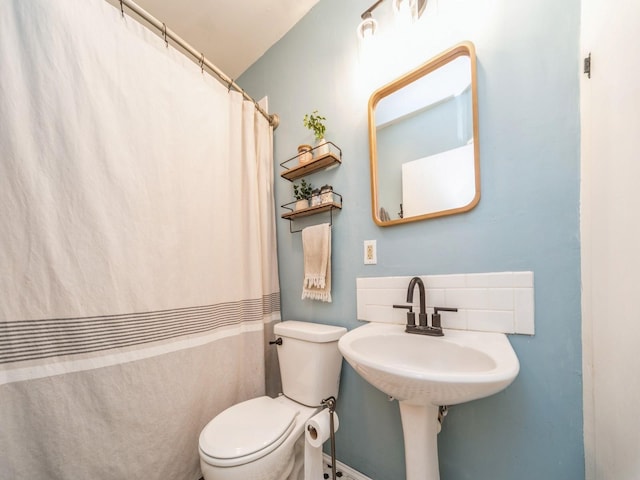 bathroom featuring toilet and a shower with shower curtain