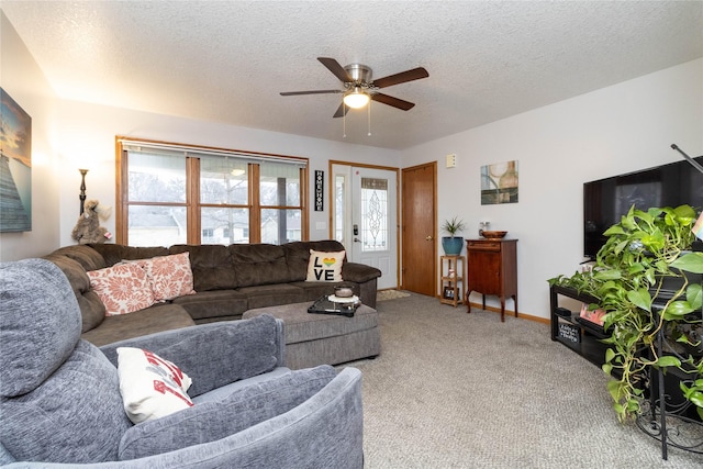 carpeted living room featuring ceiling fan and a textured ceiling