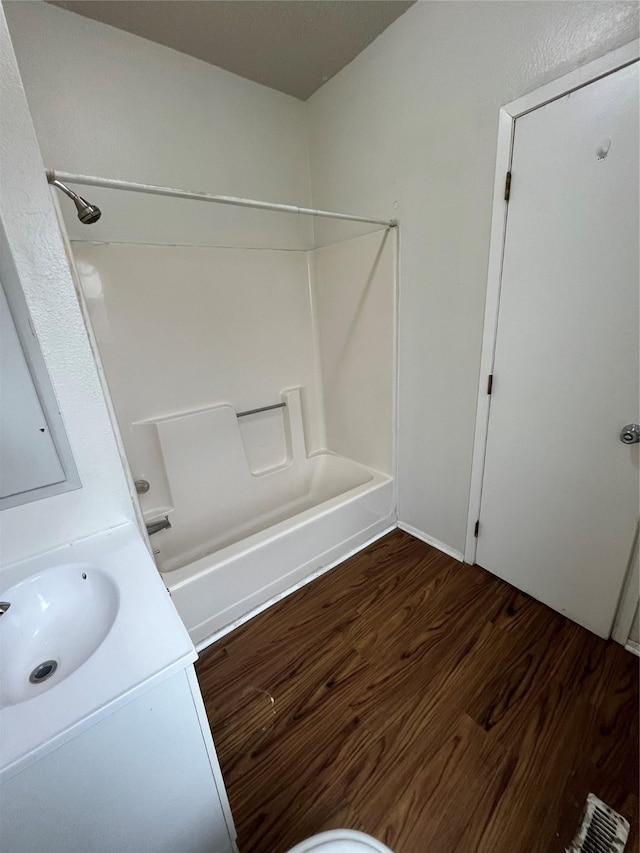 bathroom featuring wood-type flooring, bathing tub / shower combination, and vanity