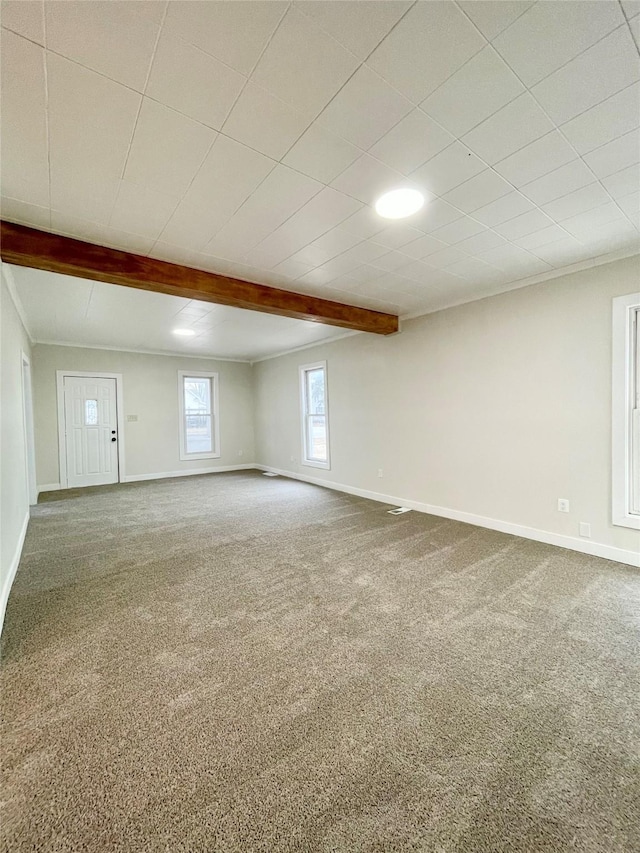 carpeted spare room featuring beamed ceiling