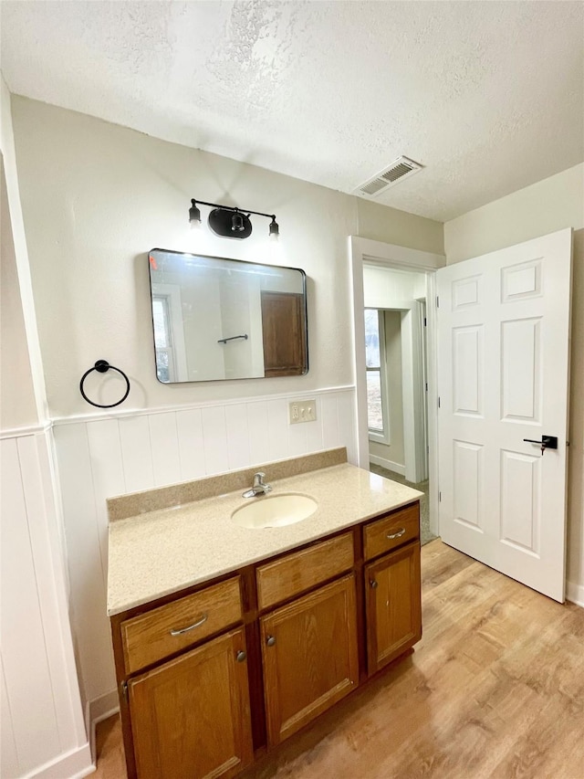 bathroom featuring vanity, hardwood / wood-style floors, and a textured ceiling