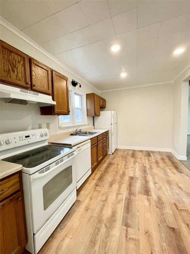 kitchen with white appliances, ornamental molding, sink, and light hardwood / wood-style flooring