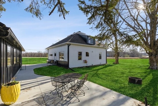 view of side of property featuring a lawn and a patio