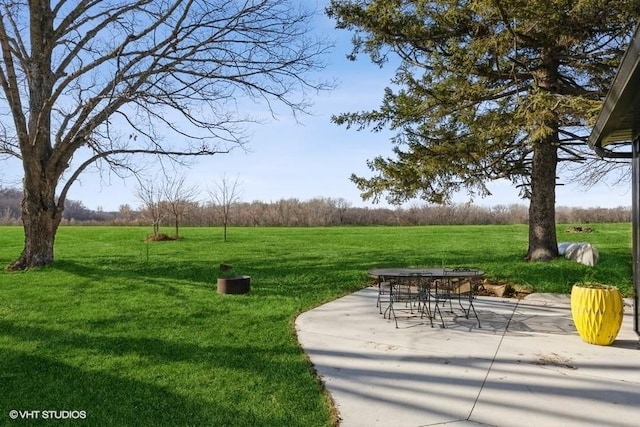 view of community featuring a patio, a yard, and a rural view