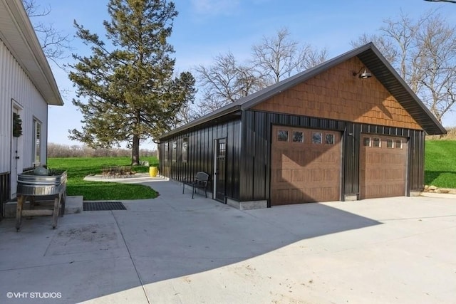 exterior space featuring a garage, board and batten siding, and an outdoor structure