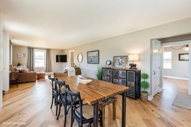 dining space featuring baseboards and light wood-style floors