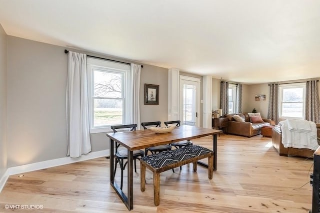 dining room with light wood-style floors, baseboards, and a wealth of natural light