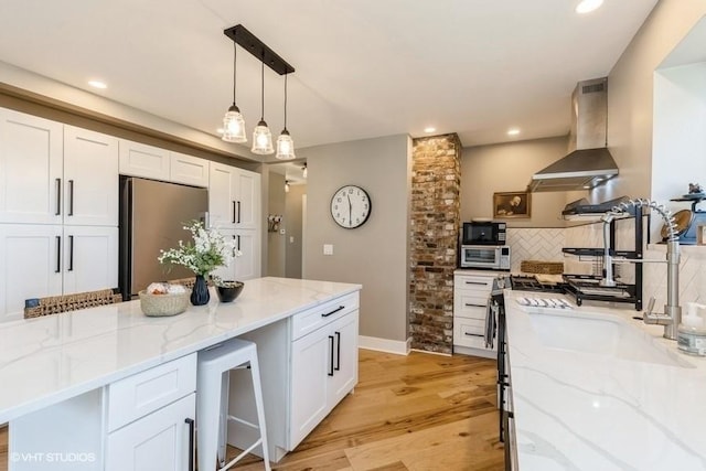 kitchen with light wood-style flooring, backsplash, appliances with stainless steel finishes, white cabinetry, and exhaust hood