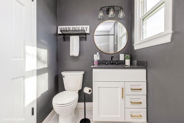 bathroom featuring vanity, toilet, and baseboards