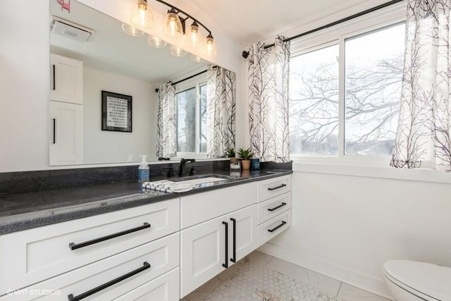 bathroom with marble finish floor, visible vents, toilet, vanity, and baseboards