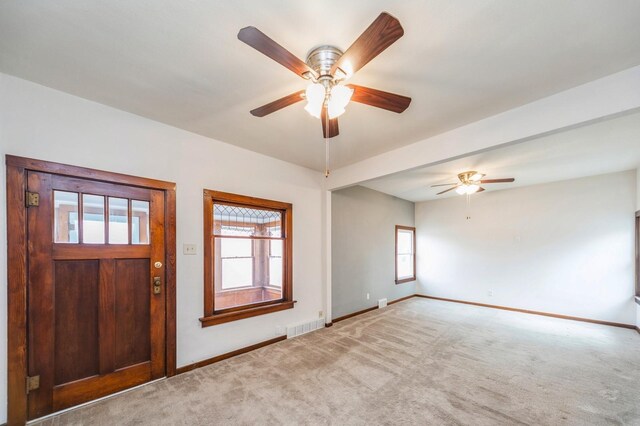 entryway featuring carpet floors, baseboards, a ceiling fan, and visible vents