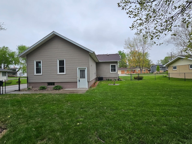 back of property featuring central AC unit, fence, and a yard