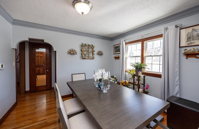 2711 Westover Blvd, Des Moines, IA 50322 - dining space featuring arched walkways, a textured ceiling, wood finished floors, and ornamental molding