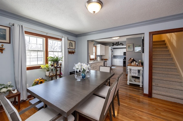 2711 Westover Blvd, Des Moines, IA 50322 - dining room featuring wood finished floors, stairs, a textured ceiling, and ornamental molding