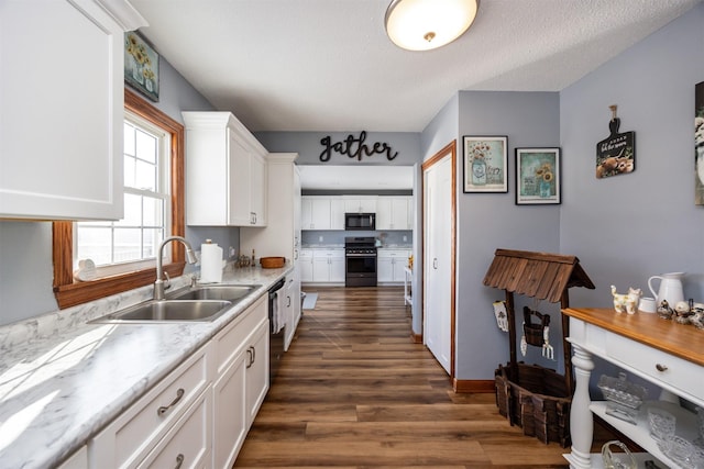 2711 Westover Blvd, Des Moines, IA 50322 - kitchen with stainless steel electric range, black microwave, white cabinetry, light countertops, and dark wood-style flooring