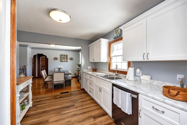 2711 Westover Blvd, Des Moines, IA 50322 - kitchen featuring dishwashing machine, white cabinets, light wood-type flooring, arched walkways, and a textured ceiling