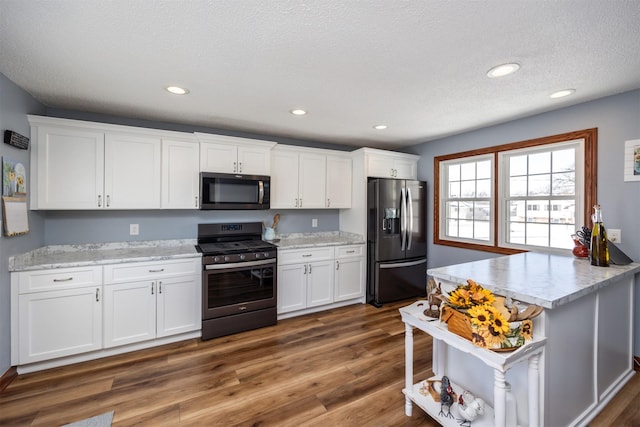 2711 Westover Blvd, Des Moines, IA 50322 - kitchen with appliances with stainless steel finishes, white cabinets, dark wood-style flooring, a textured ceiling, and recessed lighting