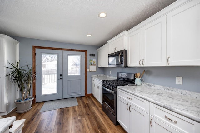 2711 Westover Blvd, Des Moines, IA 50322 - kitchen featuring stainless steel appliances, white cabinetry, dark wood-style flooring, recessed lighting, and light stone counters
