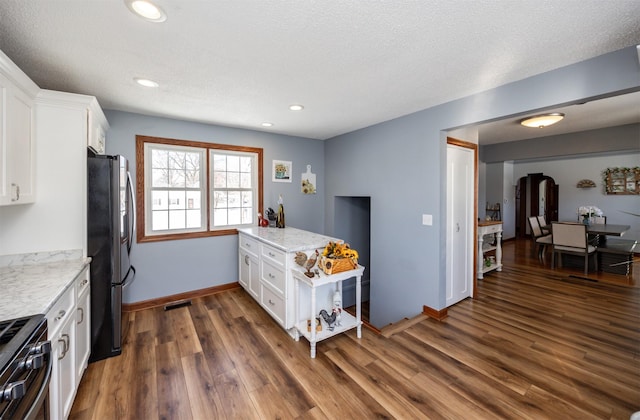 2711 Westover Blvd, Des Moines, IA 50322 - kitchen featuring freestanding refrigerator, black gas range, white cabinetry, dark wood-type flooring, and recessed lighting