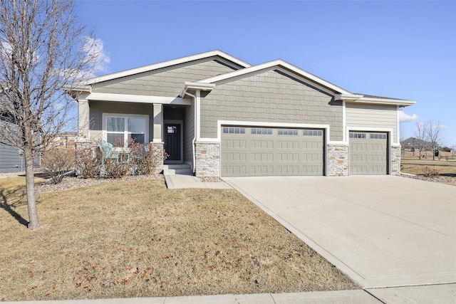 craftsman house with a garage and a front lawn