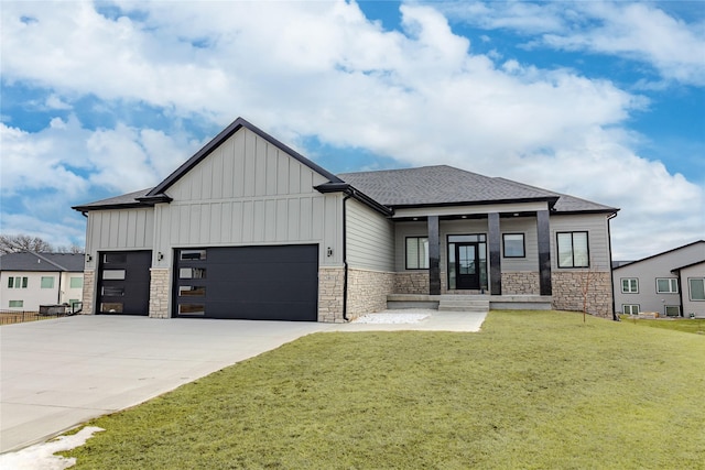 view of front of property featuring stone siding, board and batten siding, an attached garage, and a front lawn