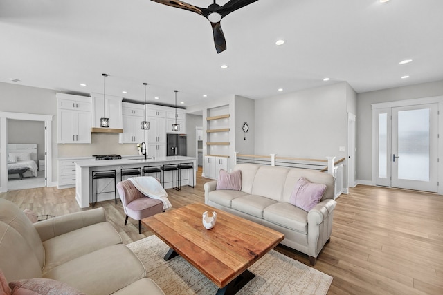 living room featuring sink and light hardwood / wood-style floors