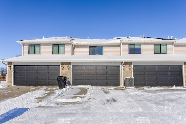 view of front of home with a garage and central air condition unit