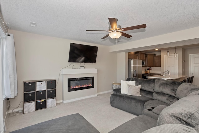 carpeted living room featuring ceiling fan and a textured ceiling