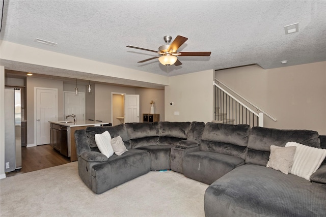 living room featuring ceiling fan, sink, and a textured ceiling