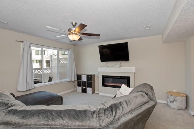 carpeted living room featuring ceiling fan and a textured ceiling