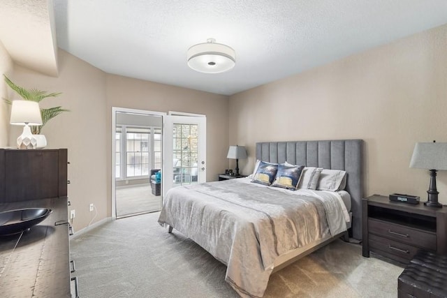 carpeted bedroom with access to exterior and a textured ceiling