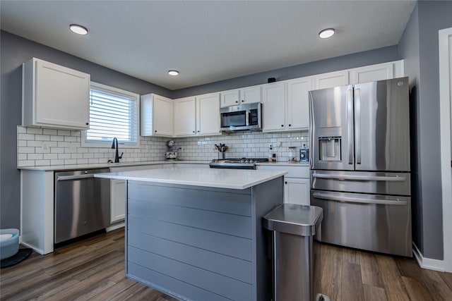 kitchen featuring stainless steel appliances, a kitchen island, and white cabinets