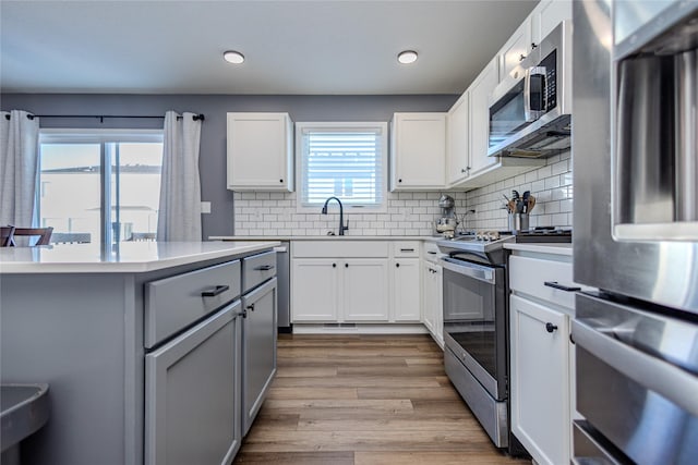 kitchen with tasteful backsplash, stainless steel appliances, and white cabinets