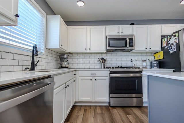 kitchen featuring stainless steel appliances, white cabinetry, dark wood-type flooring, and sink