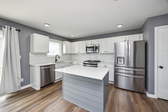 610 NE Whitetail Dr, Ankeny, IA 50021 - kitchen with stainless steel appliances, light countertops, white cabinetry, dark wood-style flooring, and recessed lighting