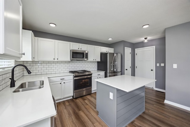 610 NE Whitetail Dr, Ankeny, IA 50021 - kitchen featuring appliances with stainless steel finishes, a center island, white cabinets, tasteful backsplash, and dark wood-style floors